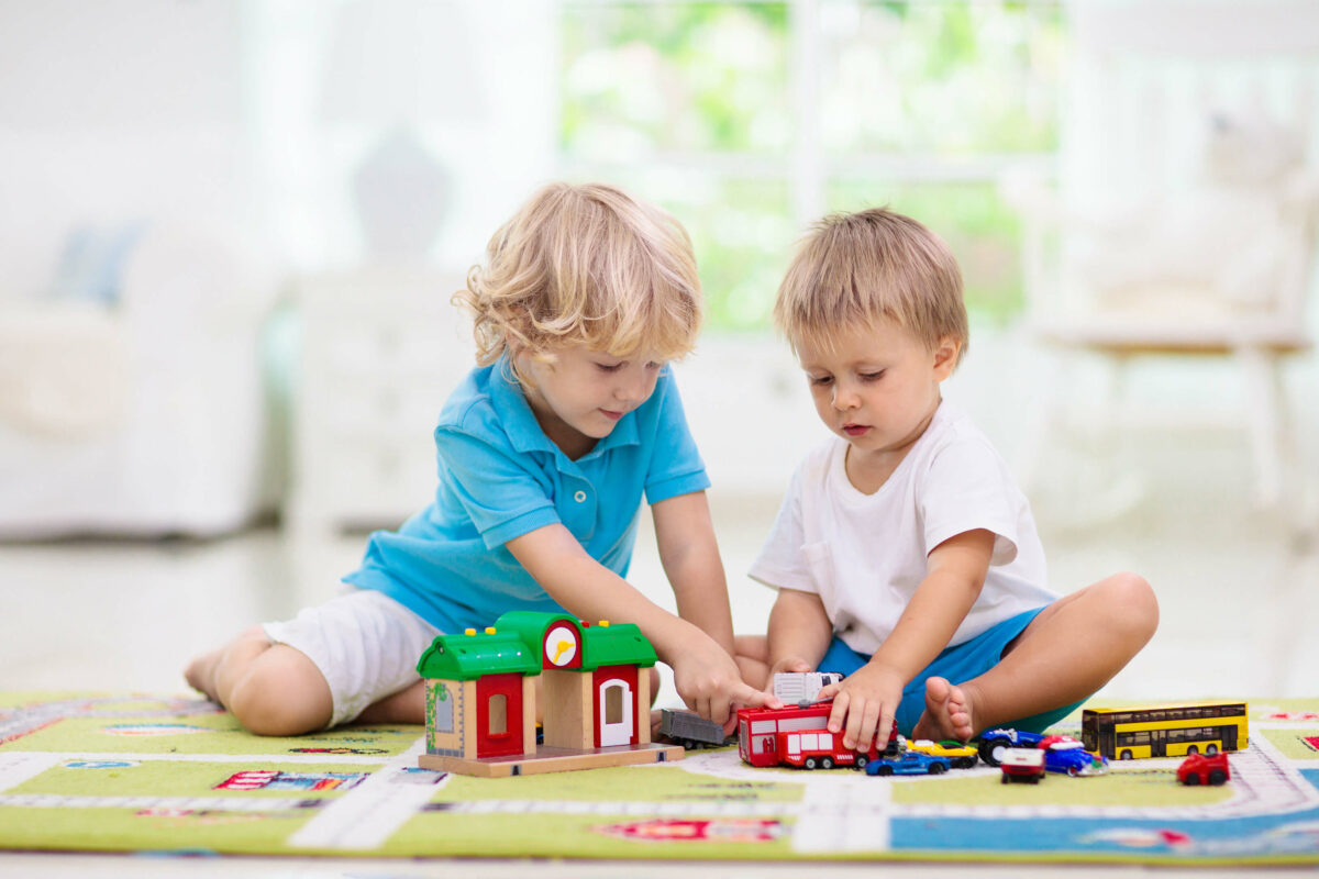 Kinder spielen auf Spielteppich