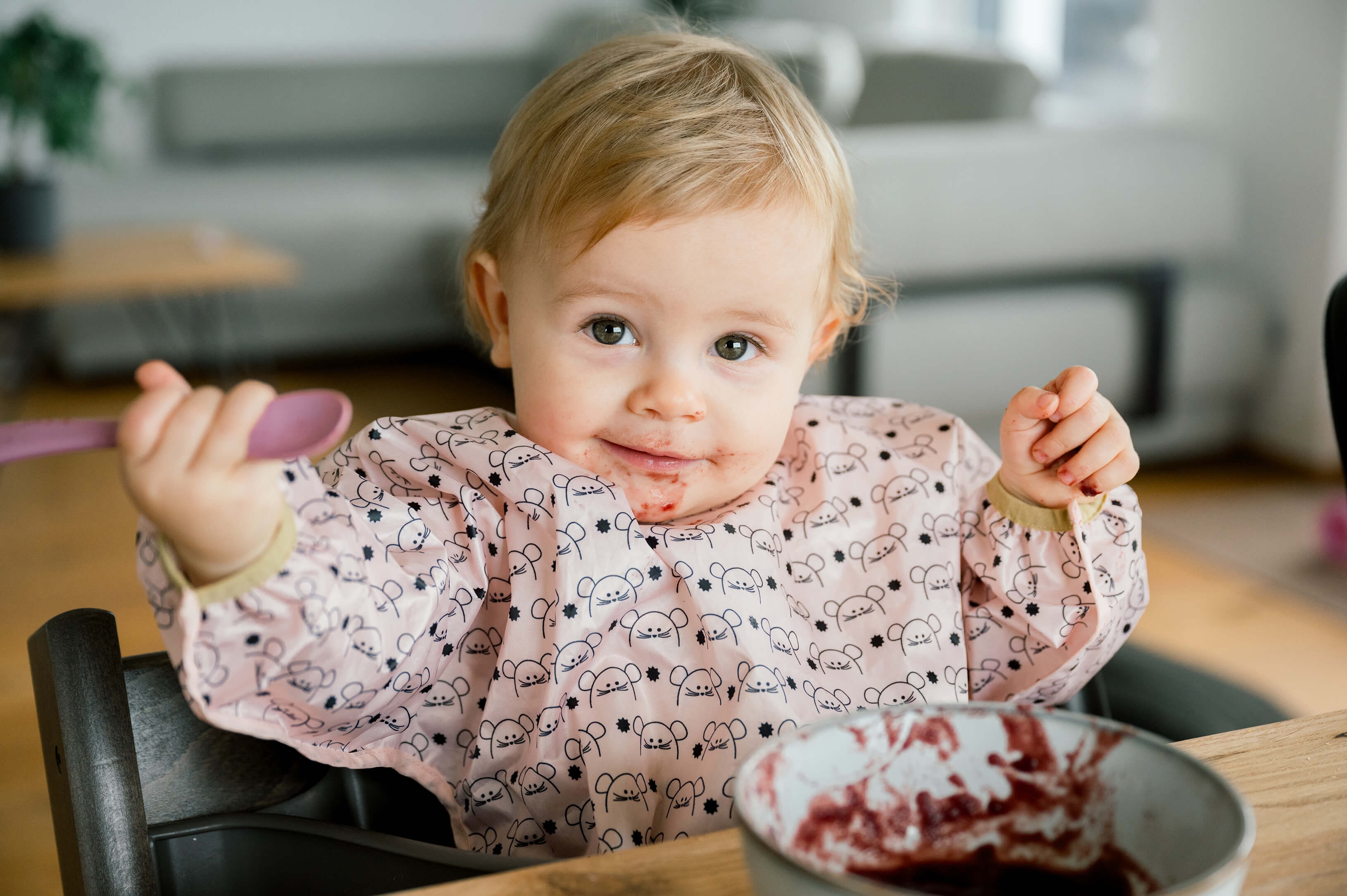 Baby hält Löffel und lernt essen